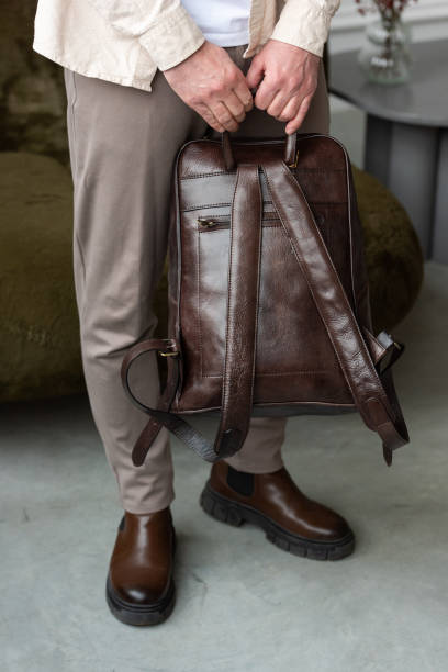 istock A Stylish and Professional Man Standing with a brown backpack in a Contemporary Modern Setting. 2193670316