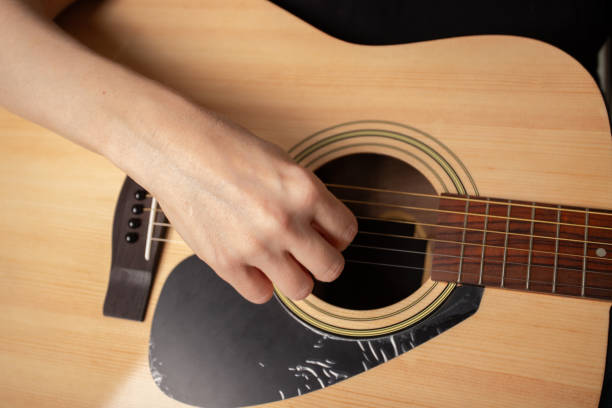 istock Hand Playing Acoustic Guitar Close-Up, studying musical instrument, education learning practice 2193670473