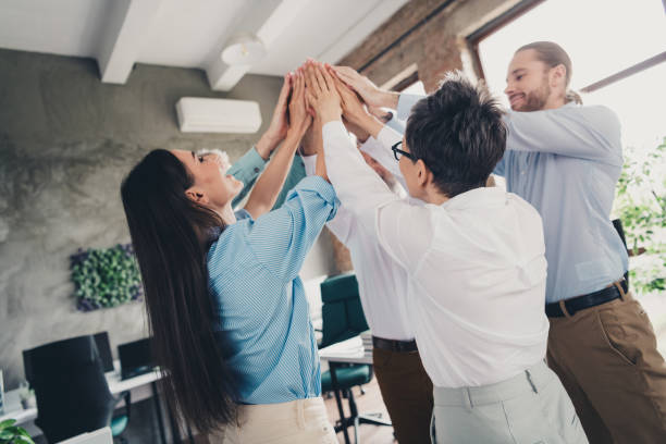 istock Photo of teamwork people working together highfive teambuilding comfortable modern office loft room interior indoors workspace 2193670597