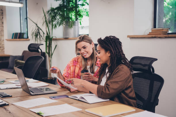 istock Portrait of two confident successful business lady communicate documents  modern business center office indoors 2193672556