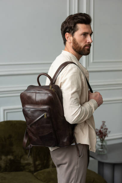 istock A Stylish and Professional Man Standing with a brown backpack in a Contemporary Modern Setting. 2193672709