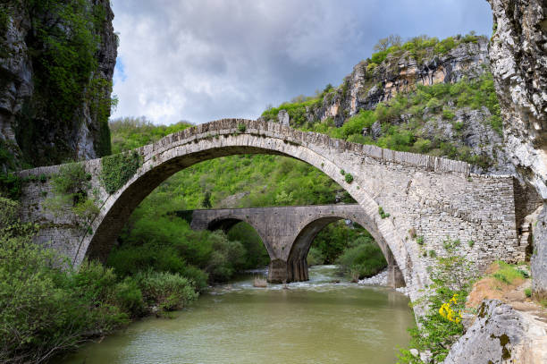 Old bridge in Greece View of the traditional stone Bridge of Noutsos or Kokkoros in Epirus, Greece in Spring zagori stock pictures, royalty-free photos & images