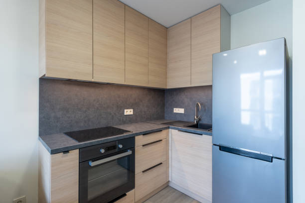 istock Modern Compact Kitchen with Wood Cabinets and Sleek Stainless Steel Refrigerator. Home Interior 2193675221