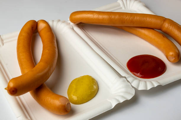 Boiled sausages on a white paper plate