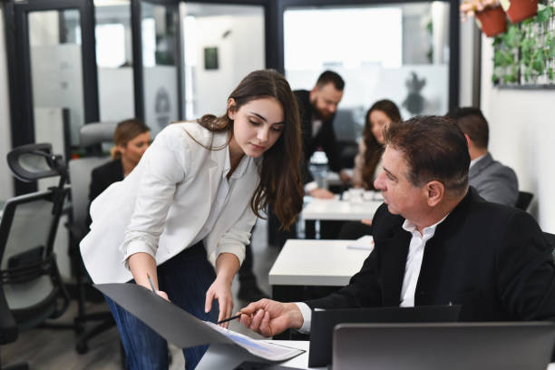 istock Male Manager Questioning Female Employee's Paperwork Asking For Explanation 2193678031
