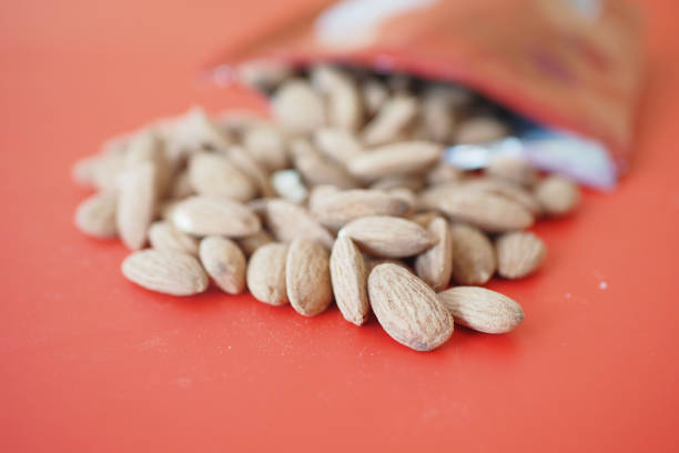 Almonds scattered from an open pouch, showcasing their lovely natural texture and color