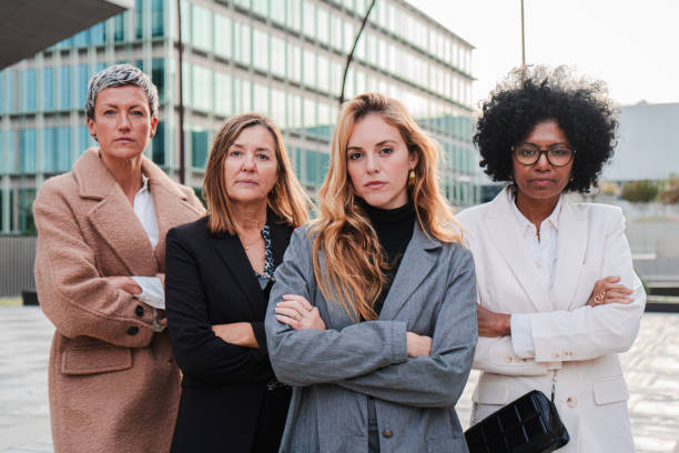 istock Real executive businesswomen looking at camera with serious and proud expression at downtown workplace. Toughtful and strong arms crossed business women staring front. Corporate female colleagues 2193680884