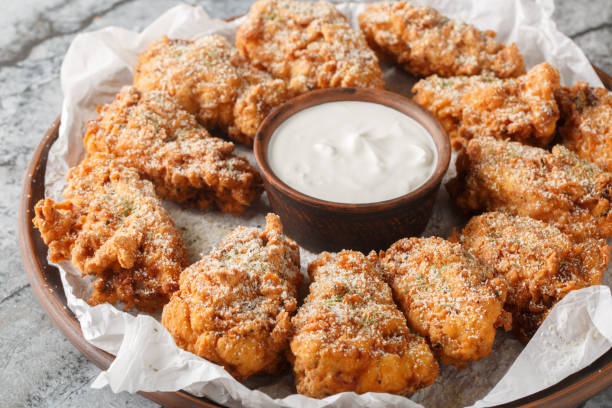 istock Breaded Bburinkle fried chicken wings in cheese garlic onion breading with dipping sauce close-up in plate. Horizontal 2193682642
