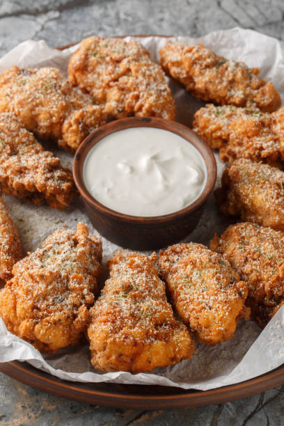 istock Korean Bburinkle Chicken is a crispy fried chicken with a cheesy, onion, and garlic coating closeup on the plate. Vertical 2193682678