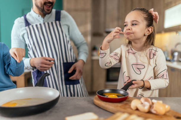 istock A young father is preparing breakfast at home with his children. 2193683844