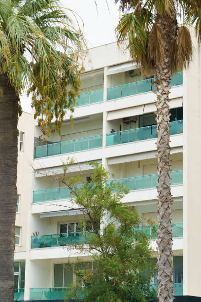 istock Vertical image modern minimalist apartment buildings in Mediterranean style with palm trees in Albania near the sea coast. Concept of foreign real estate, digital nomads, apartment rental in resort 2193685079