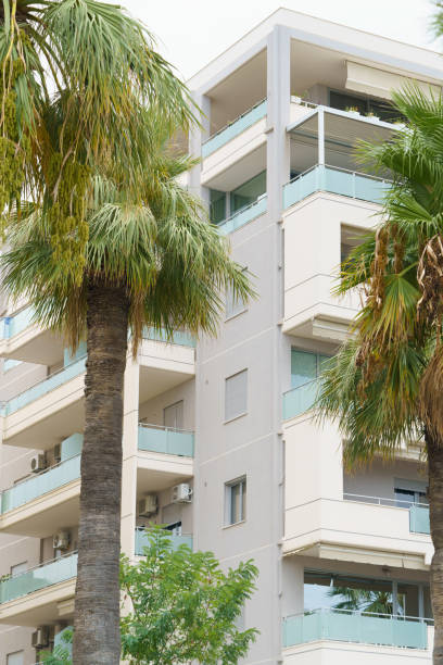 istock Vertical image modern minimalist apartment buildings in Mediterranean style with palm trees in Albania near the sea coast. Concept of foreign real estate, digital nomads, apartment rental in resort 2193685154