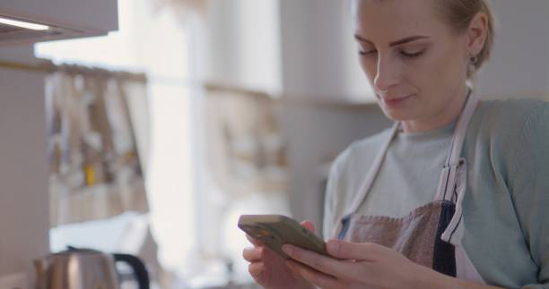 istock Woman Reading Recipe While Baking in Pan in Kitchen 2193686843