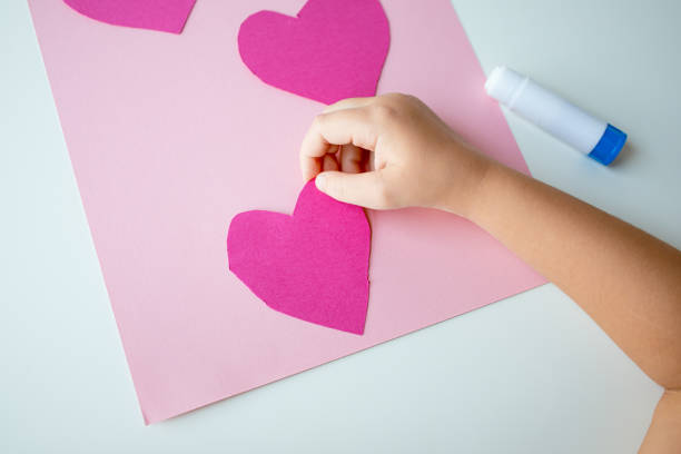 istock Child creating pink heart craft on pink paper 2193686864