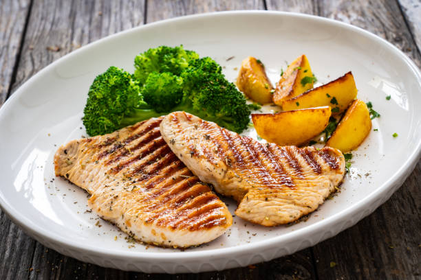 istock Barbecued turkey breast and broccoli on wooden table 2193688334