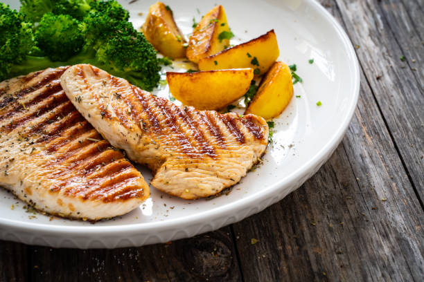 istock Barbecued turkey breast and broccoli on wooden table 2193688401
