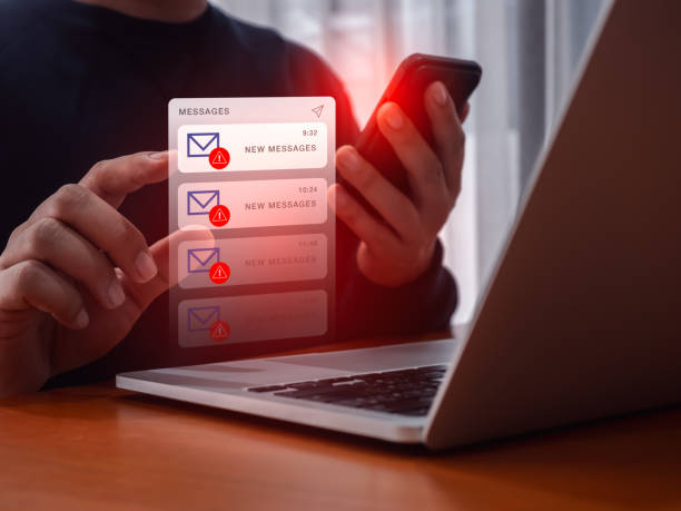 SMS scam or fake text message phishing concept. System hacked warning alert, email hack, scam malware spreading virus on messages alert virtual on mobile smart phone screen in person people hand.