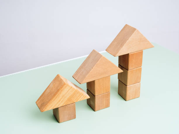 istock Three wooden arrowhead built by cube blocks as bar graph chart steps on green table, white background. Business growth, Investment, income develop, trends, leadership, economic improvement concepts. 2193694266