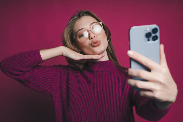 istock A Trendy and Stylish Selfie Featuring a Playful Expression Set Against a Bright Pink Background 2193694346