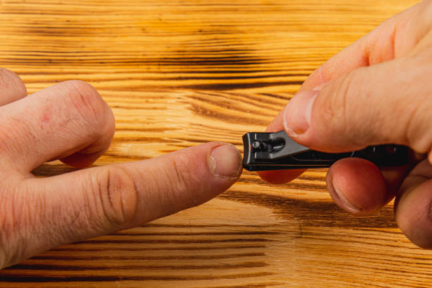 istock Proper nail trimming technique on a wooden surface with male hands 2193697132