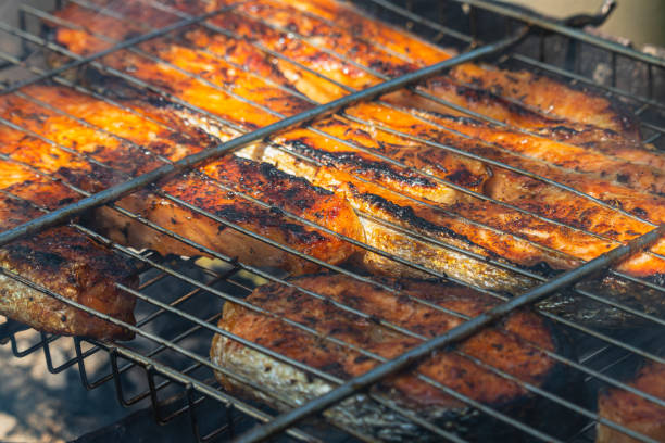 istock Salmon and trout sizzling on a barbecue grill during a summer gathering 2193698188
