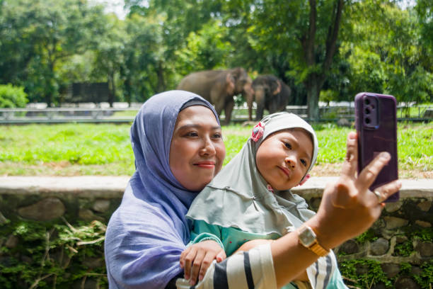 Mother and daughter taking a photo together using a cellphone