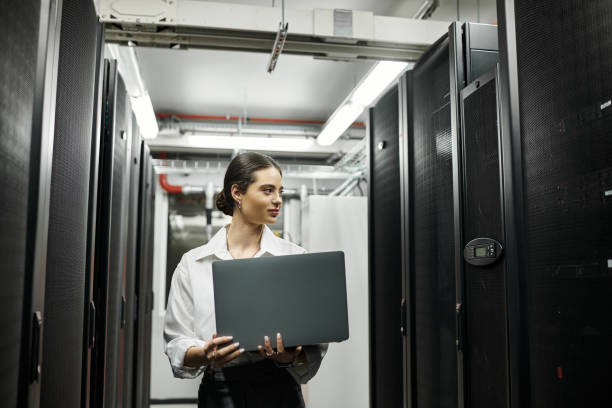 istock Professional woman working in a modern server room focused on cybersecurity tasks 2193699214
