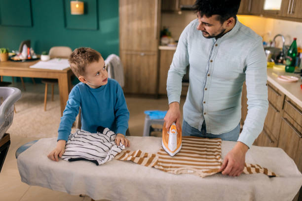 The child's careless behavior in playing with a hot iron in the living room could result in burns or injuries to the baby if left unsupervised. Kid aged about two years (one year ten months)