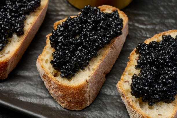 istock Sandwich with baguette and black caviar on a black board 2193700640