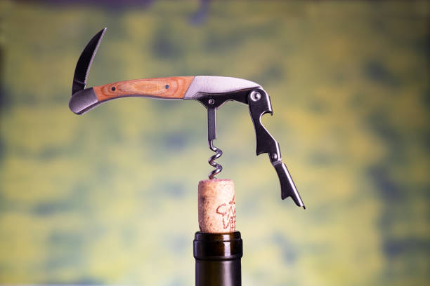 istock Professional sommelier or waiter knife pulls out a cork from the bottle of red wine. Corkscrew and bottle opener close-up macro. 2193701874