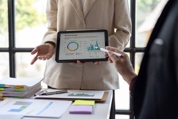 istock Meetings discuss business situations by analyzing financial charts in company reports on digital tablets to analyze strategies and plan new investment projects to increase profits. 2193704335