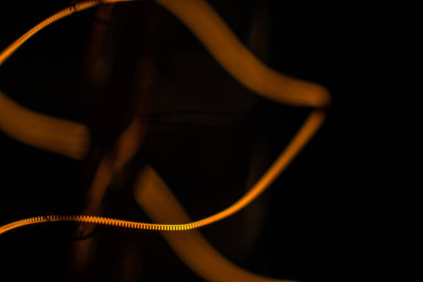 Shining filament of edison light bulb on black backdrop, macro shot