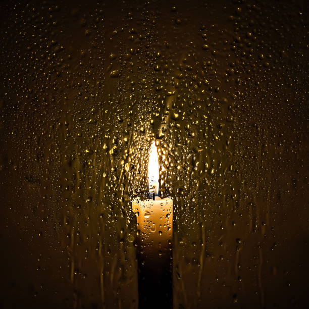 istock Burning candle behind glass with water drops 2193705327