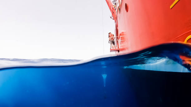 A red research vessel floats partially above water ready for marine observation and scientific study in open sea
