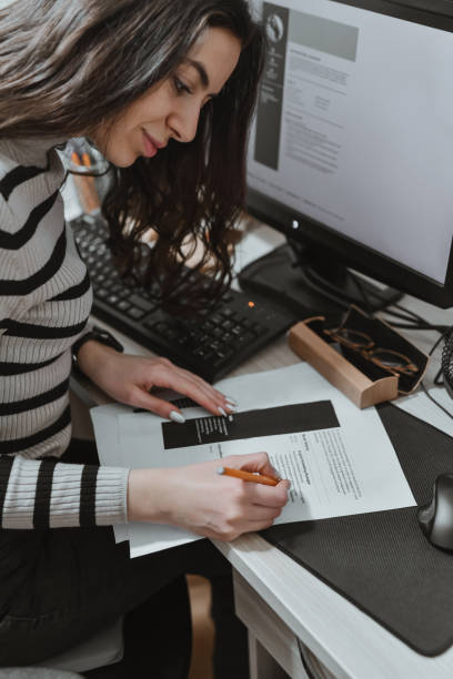 istock Beautiful Female Examining Her CV Correcting it With Pencil Before Applying for Job 2193706374