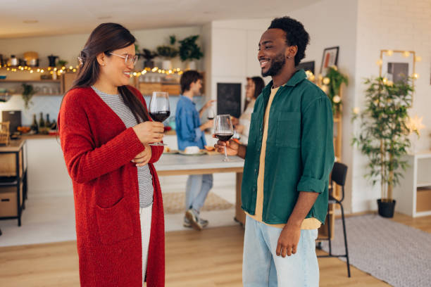 istock Smiling black man drinking wine with his Asian friend while spending Christmas day at home together 2193707274