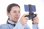 asiatische-frau-die-videospiele-auf-dem-smartphone-mit-einem-controller-spielt.jpg?b=1&s=170x170&k=20&c=4wbYYWx36jnh5rNCppGInugLMX4KB0KvhRnhQjfnes0=