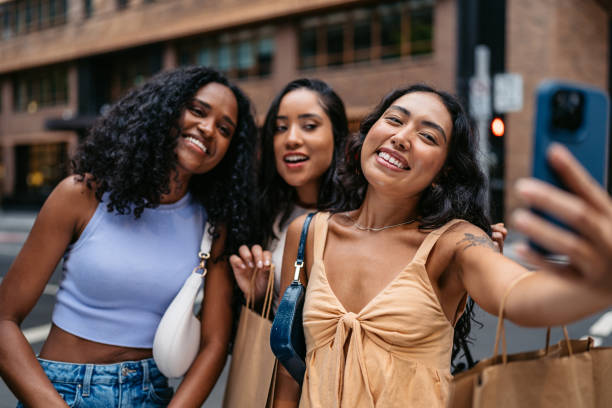 istock Three Young Female Friends Taking Selfies Using Phone While Carrying Shopping Bags On The Street In Sydney In Australia 2193710131