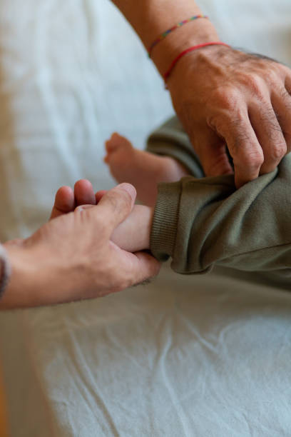 istock Crop dad dressing newborn on bed 2193711199