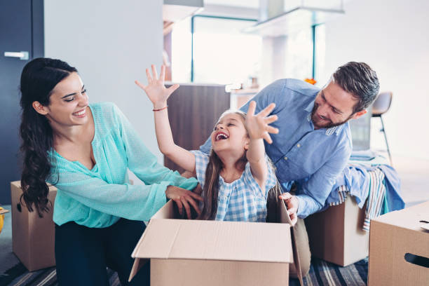 istock Little girl playing inside a cardboard box while unpacking in a new home 2193712298