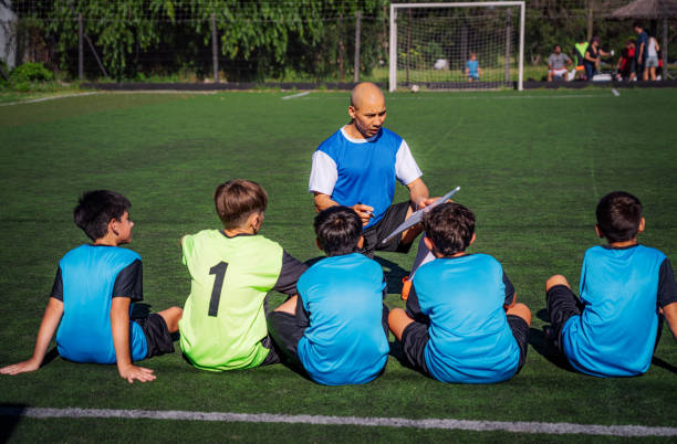 istock Youth Soccer Team Coaching Session with Players Sitting in a Circle 2193714737