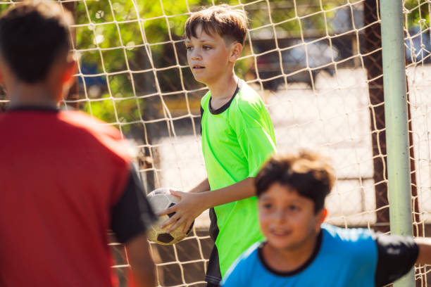 Energetic group of children enjoying a game of soccer on a sunny day in a community park. The scene shows teamwork, excitement, and an active lifestyle, promoting youth sports and social bonding.