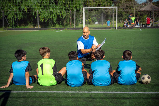 istock Coach Guiding Young Soccer Players During Training Session on Green Field 2193715256