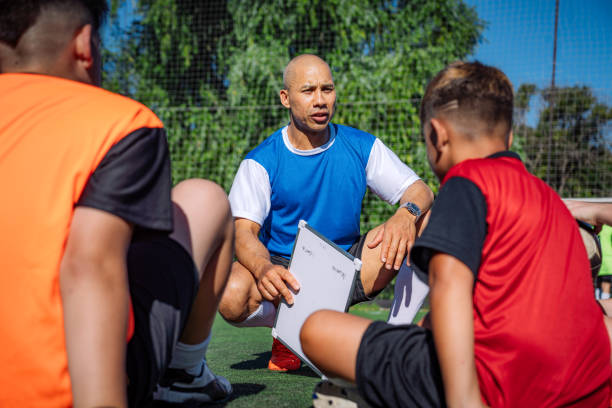 istock Coach Giving Instructions to Kids on a Soccer Field 2193717144