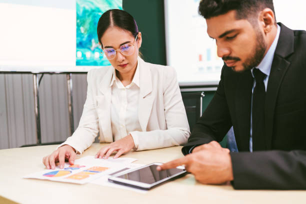 istock A professional meeting scene showing two individuals discussing data, with charts and a tablet on the table, reflecting collaboration and analysis. Asian business woman leader role at the meeting. 2193717308