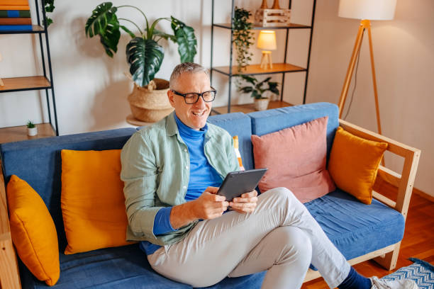 istock Middle age man spending time home alone in living room and enjoying it 2193720504