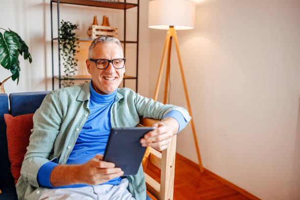 istock Middle age man spending time home alone in living room and enjoying it 2193720581