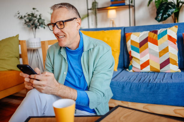 Middle age man spending time home alone in living room and enjoying coffee