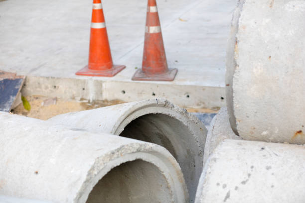 Stacked new concrete  sewer tubes at street construction site in residential district of Bangkok Chatuchak/Ladparo