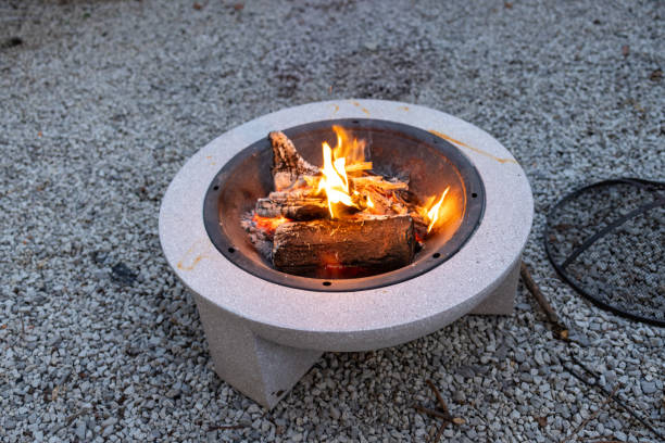 istock Outdoor Fire Pit with Burning Wood on Gravel Surface 2193723433